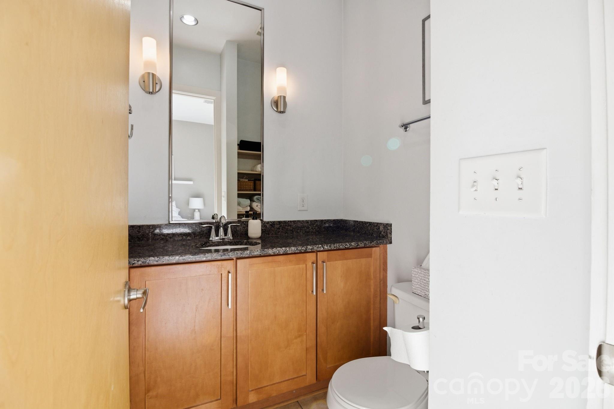 2116 McClintock Road, Unit 123 Charlotte, NC 28205 - Photo 12 of 28 a bathroom with a granite countertop sink and a mirror
