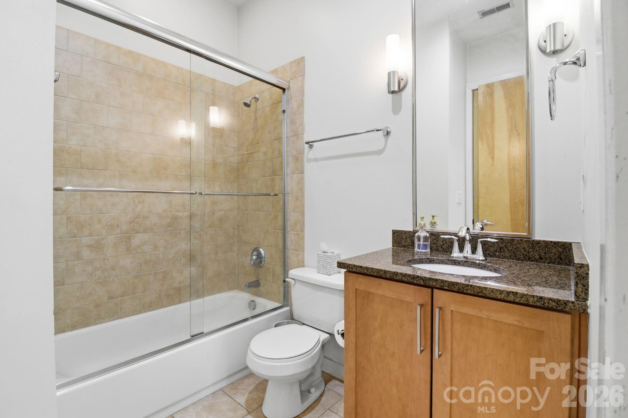 2116 McClintock Road, Unit 123 Charlotte, NC 28205 - Photo 13 of 28 a bathroom with a granite countertop sink toilet and shower