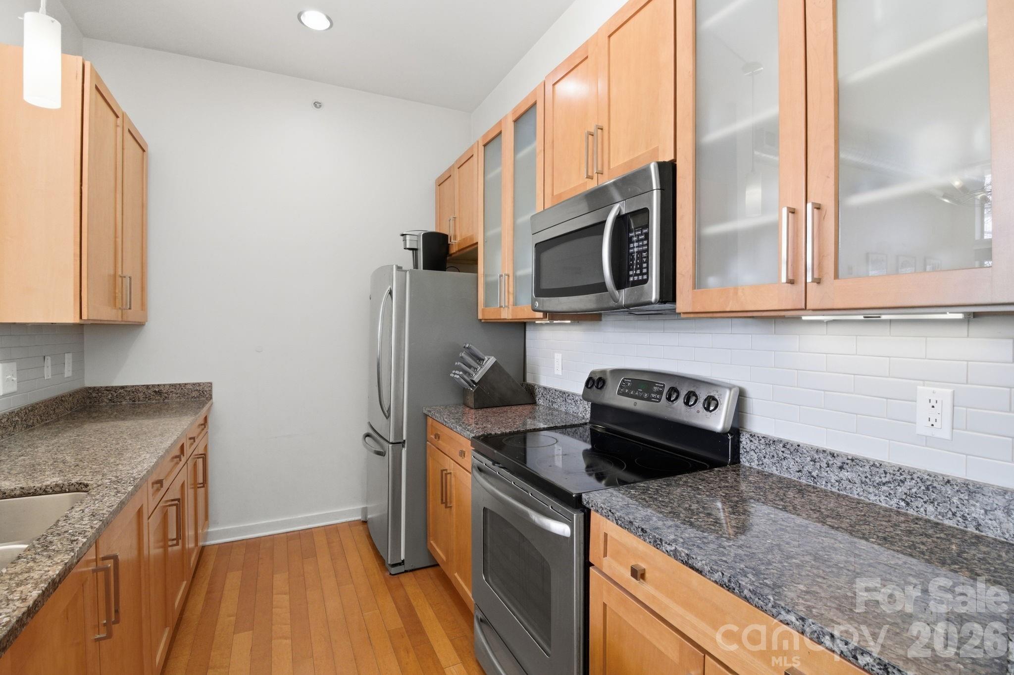 2116 McClintock Road, Unit 123 Charlotte, NC 28205 - Photo 7 of 28 a kitchen with stainless steel appliances granite countertop a stove a sink and a microwave