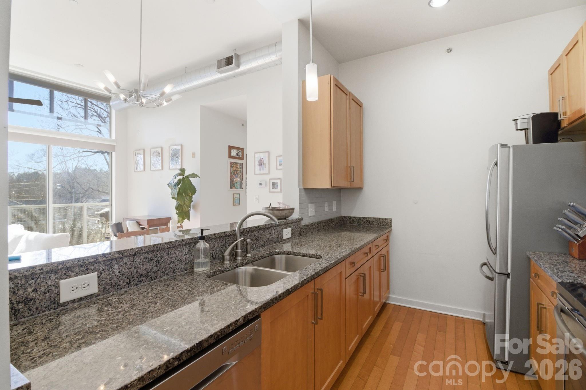 2116 McClintock Road, Unit 123 Charlotte, NC 28205 - Photo 8 of 28 a kitchen with granite countertop a sink a counter top space and cabinets