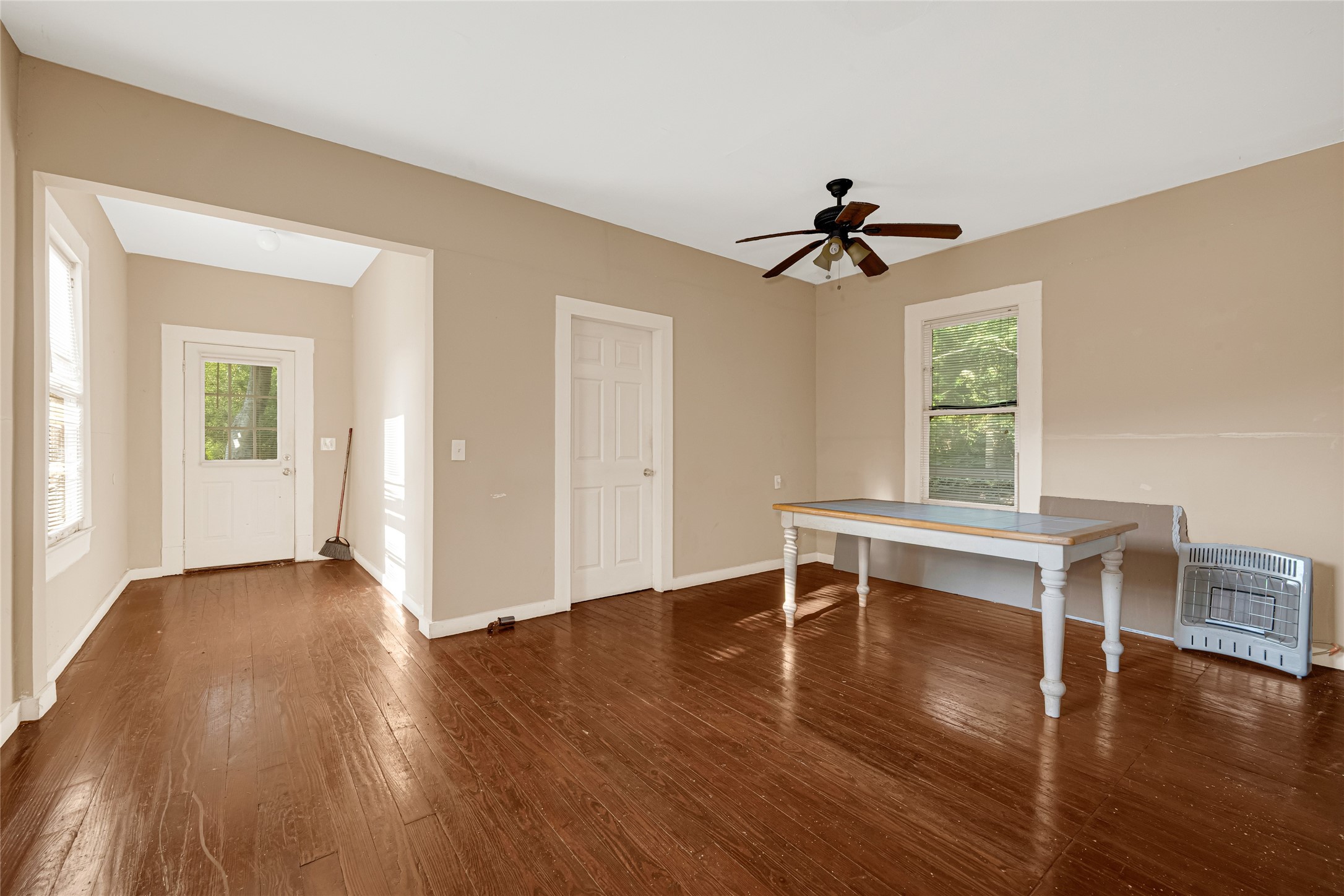 7305 Tremper Street Houston, TX 77020 - Photo 8 of 28 a view of a workspace with wooden floor and a chandelier fan