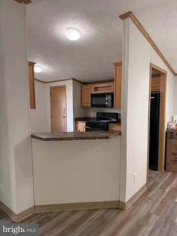 a view of a kitchen with stainless steel appliances granite countertop a refrigerator and a sink