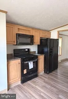 a kitchen with stainless steel appliances a stove a microwave and a hard wood floor