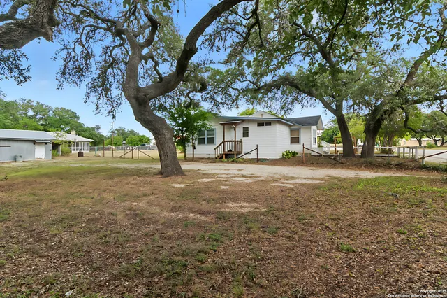 a view of house with yard and trees