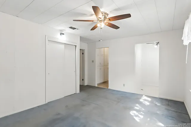 an empty room with closet and fan
