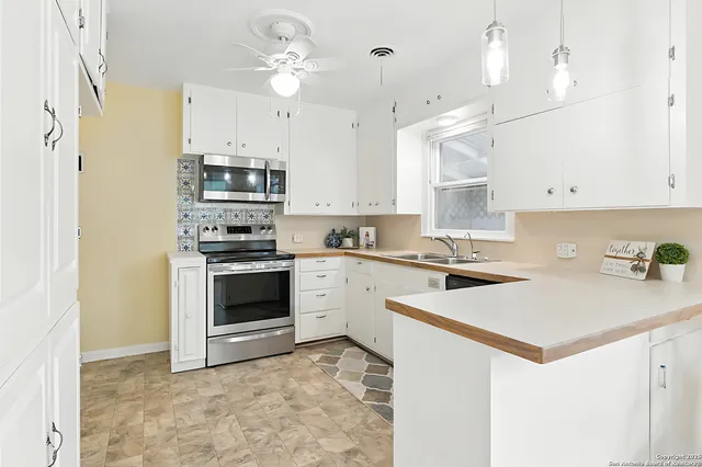 a kitchen with kitchen island a stove a sink and a refrigerator