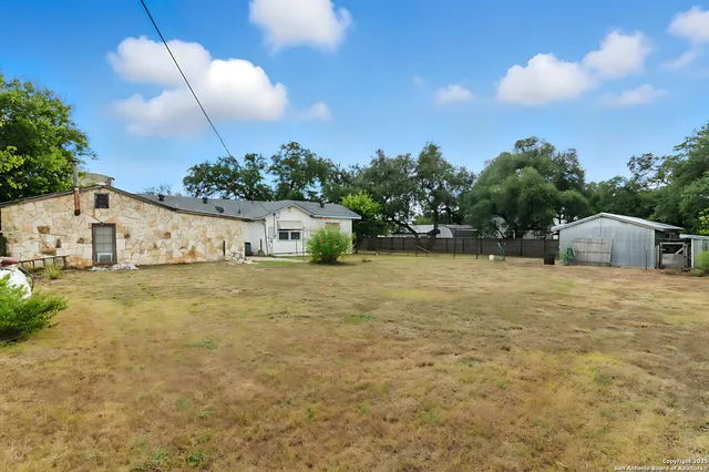 a view of a house with backyard and a tree