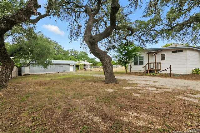 a backyard of a house with table and chairs
