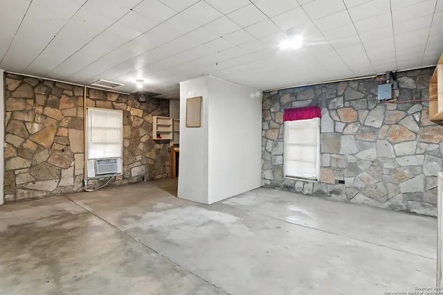 a view of an empty room with cabinet and stairs