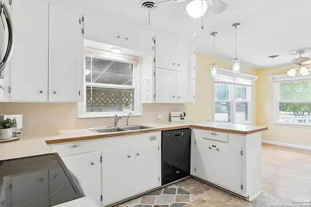 a kitchen that has a sink a window and stainless steel appliances