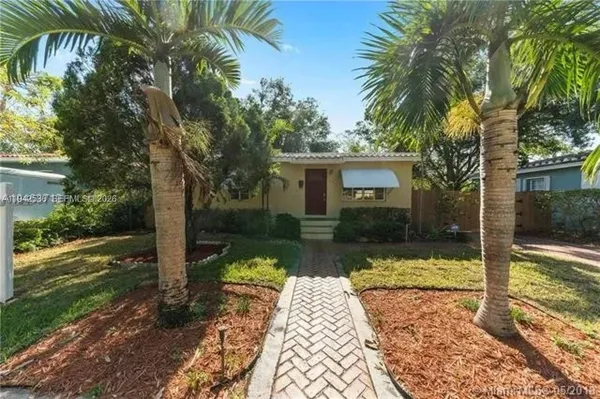 a view of a entrance gate of the house and trees