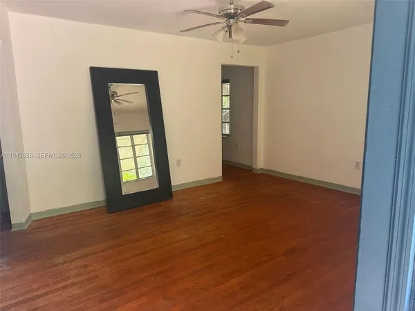an empty room with fan and windows