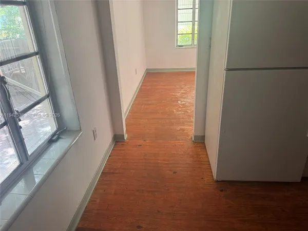 a view of a hallway with wooden floor and a hallway