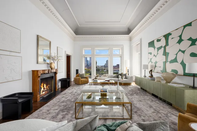 a living room with fireplace furniture and a large window