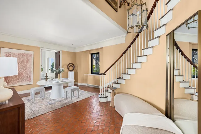 a living room with couches and a dining table with wooden floor
