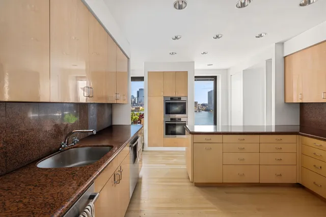 a kitchen with granite countertop a sink a stove and cabinets