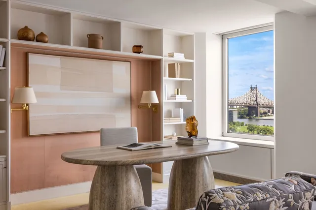 a view of a workspace with furniture and a window