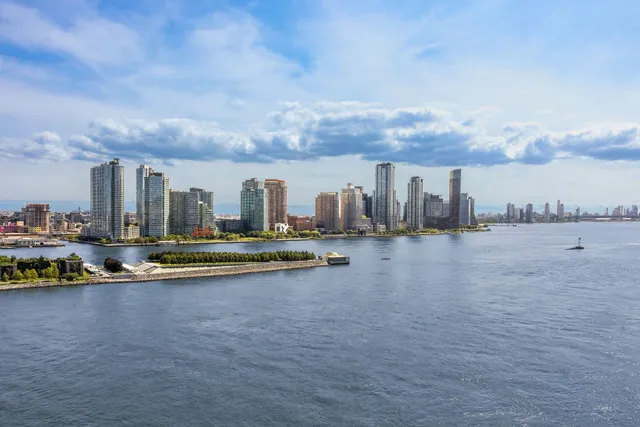 a view of water with tall buildings in the background