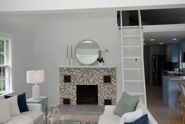 a living room with furniture a mirror and a fireplace