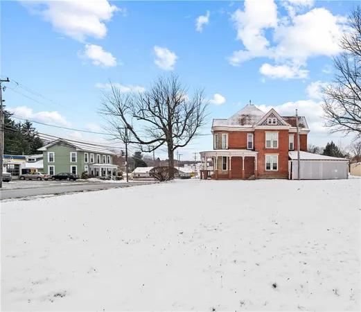 a front view of a building with snow on the road