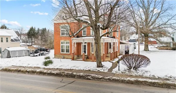 a view of a house with a yard covered in snow