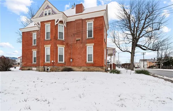 a front view of a building with snow on the road
