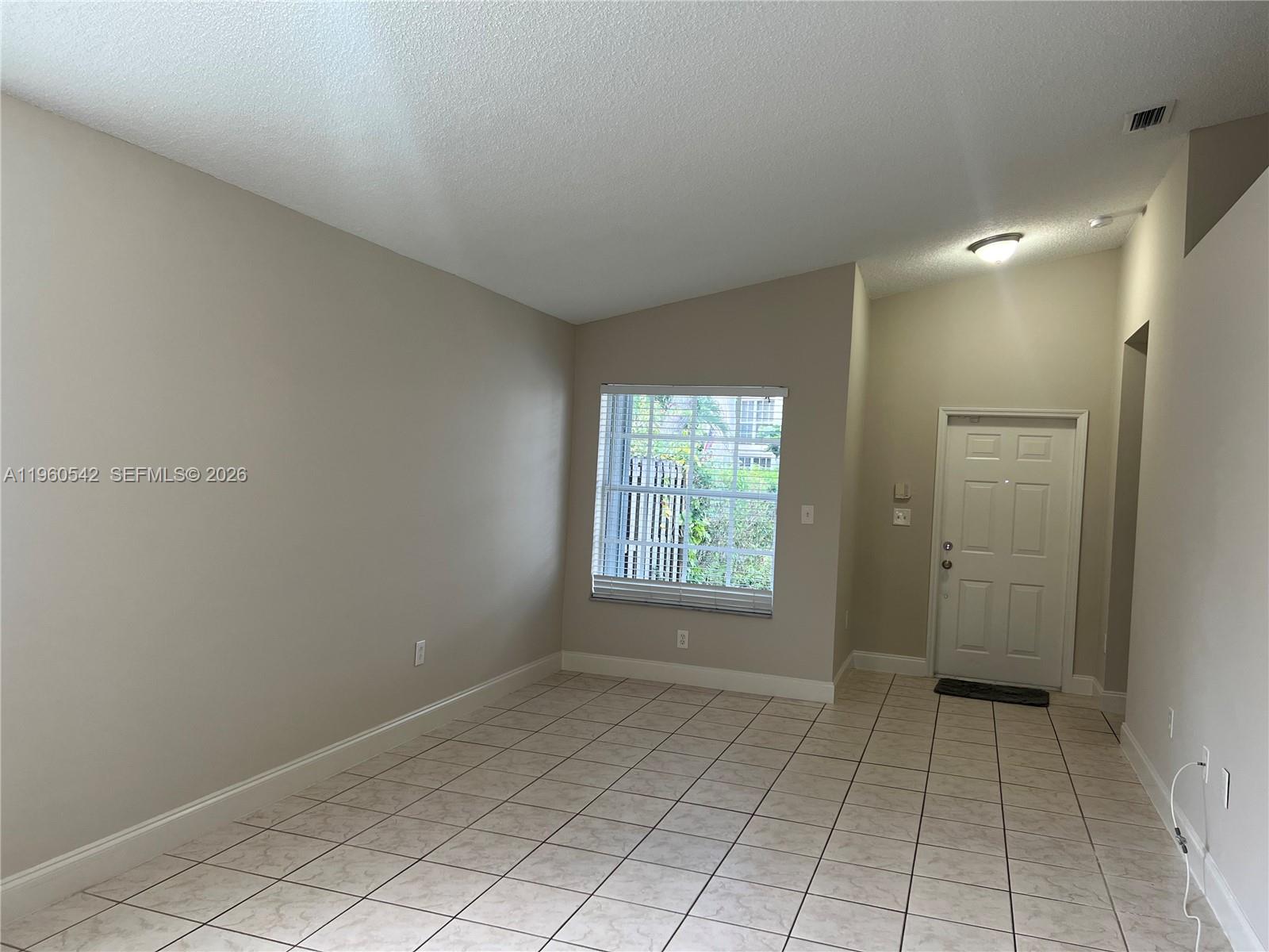 14225 Southwest 149th Avenue, Unit 14225 Miami, FL 33196 - Photo 2 of 19 a view of an empty room and window