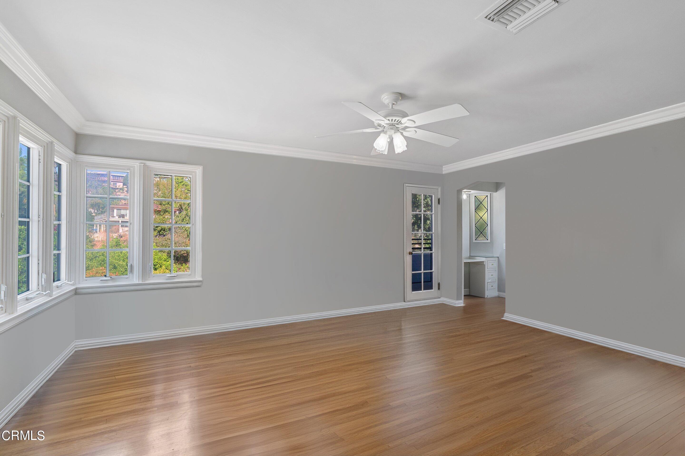 1637 Valley View Road Glendale, CA 91202 - Photo 39 of 66 an empty room with wooden floor chandelier fan and windows