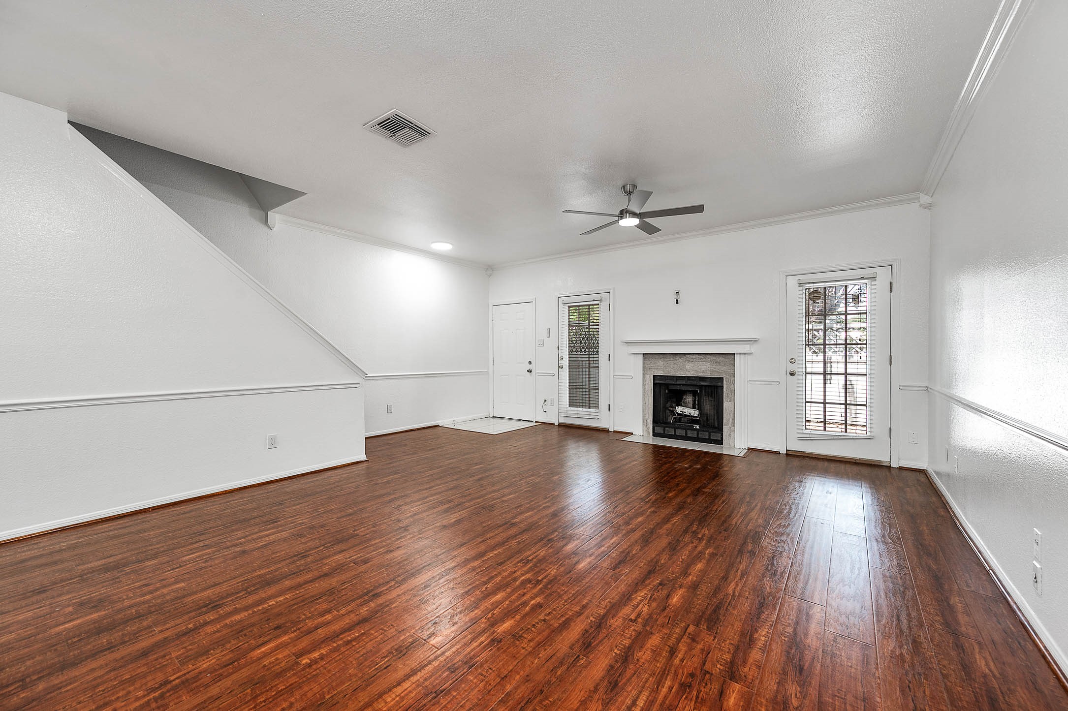 6000 Reims Road, Unit 2003 Houston, TX 77036 - Photo 6 of 24 an empty room with wooden floor fireplace and windows