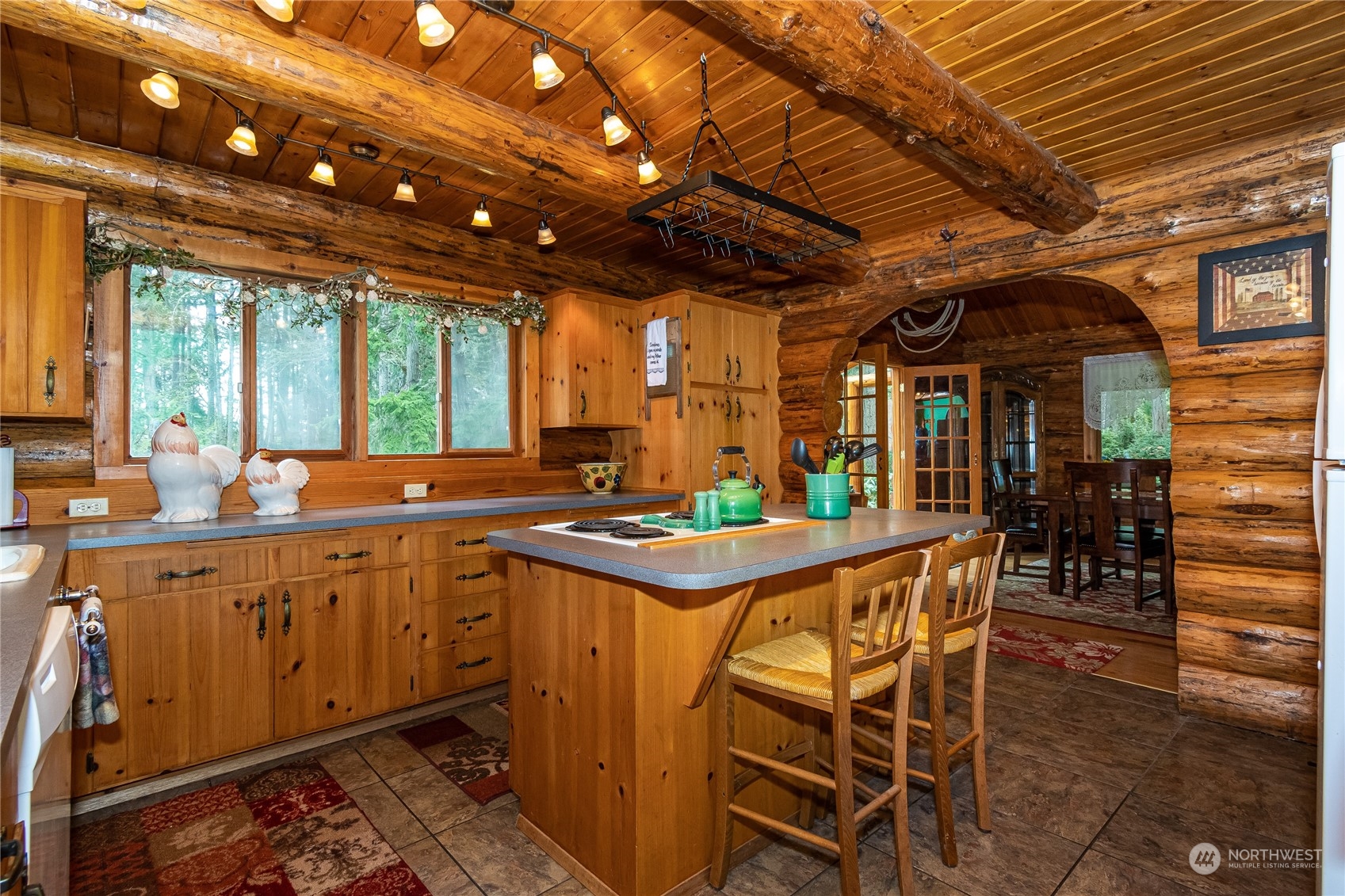8526 Davenport Road Anderson Island, WA 98303 - Photo 15 of 31 a kitchen with stainless steel appliances granite countertop a sink a counter space and a dining table