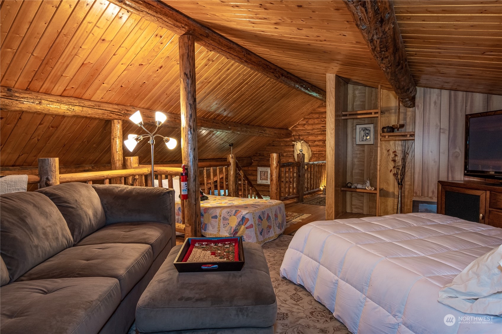 8526 Davenport Road Anderson Island, WA 98303 - Photo 22 of 31 a large bedroom with a bed a couch and large window