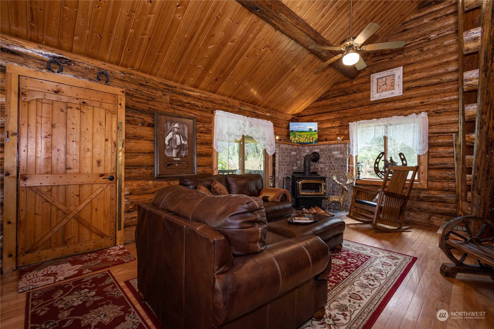 8526 Davenport Road Anderson Island, WA 98303 - Photo 9 of 31 a living room with furniture a flat screen tv and a table