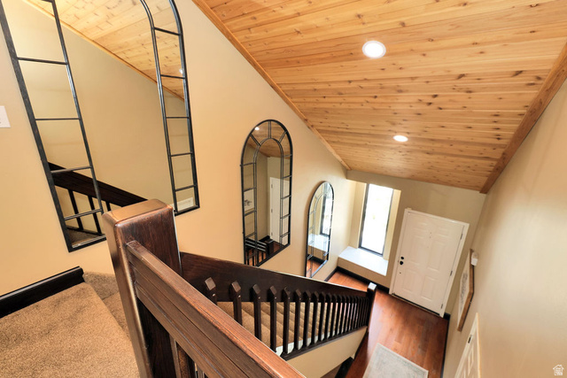 3104 East High Danish Road Sandy, UT 84093 - Photo 16 of 36 Staircase featuring dark wood-finish banister and carpeted treads, complemented by a wood-paneled ceiling with recessed lighting