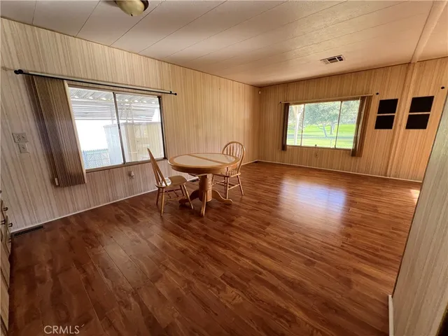 a view of a livingroom with wooden floor and furniture