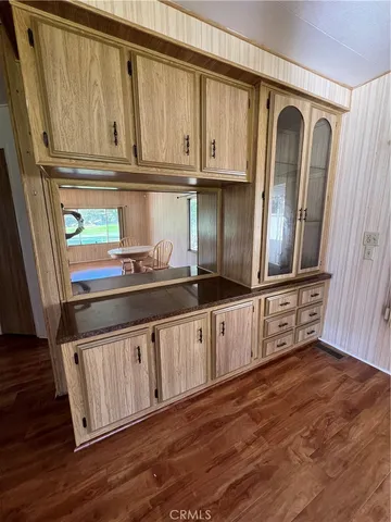 a view of a kitchen with granite countertop wooden cabinets and a wooden floor