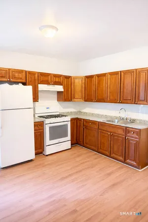 a kitchen with granite countertop a sink stainless steel appliances and cabinets
