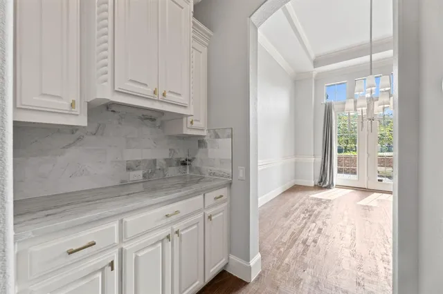a kitchen with granite countertop white cabinets and sink