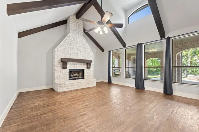 a view of an empty room with a fireplace and a window
