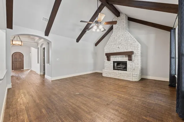 a view of a livingroom with wooden floor and a fireplace