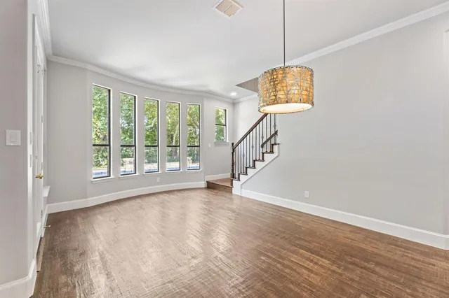 a view of a room with wooden floor and chandelier