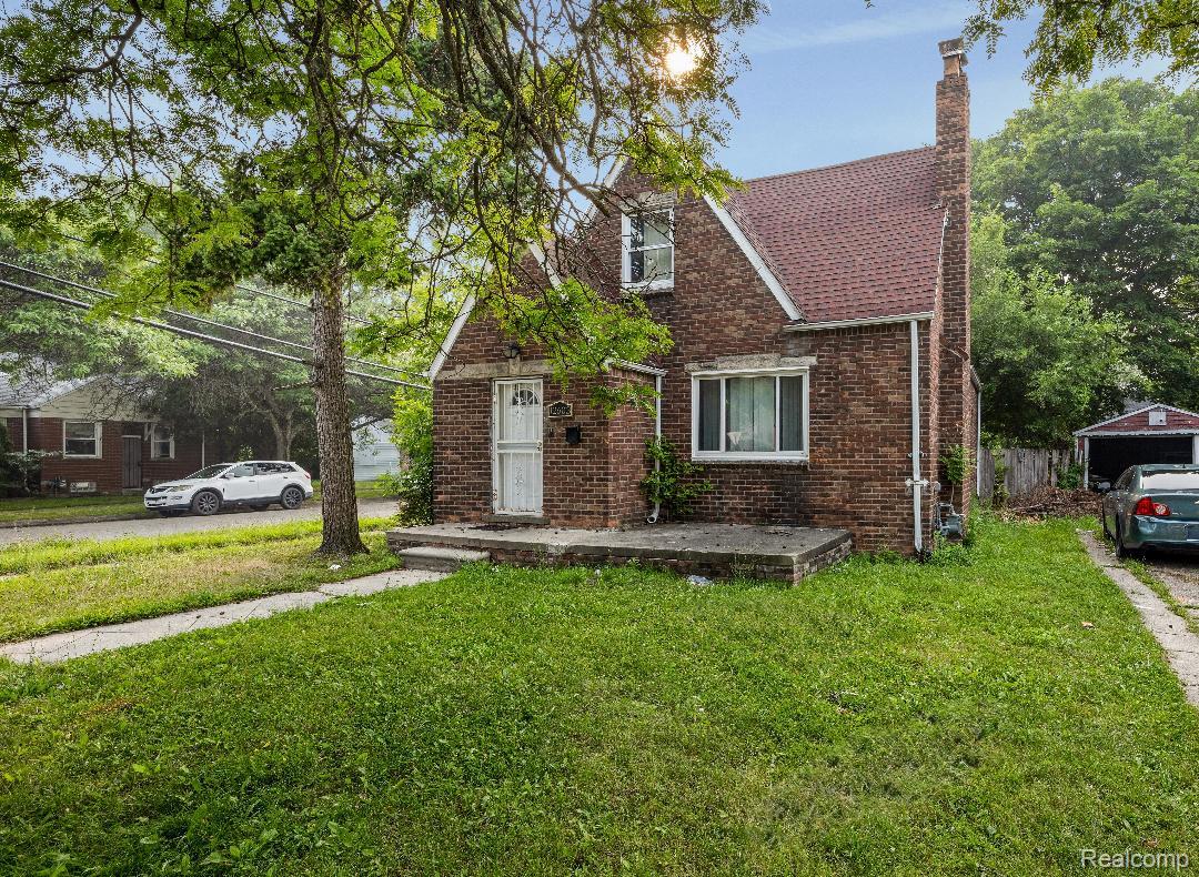 12603 Riad Street Detroit, MI 48224 - Photo 2 of 16 Brick exterior with a prominent chimney, concrete front porch, and a red-toned shingle roof