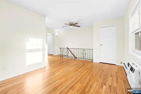 a view of a room with wooden floor and a ceiling fan