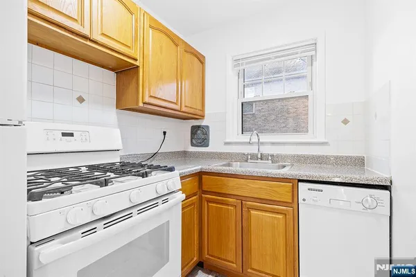 a kitchen with granite countertop cabinets stainless steel appliances a sink and a window