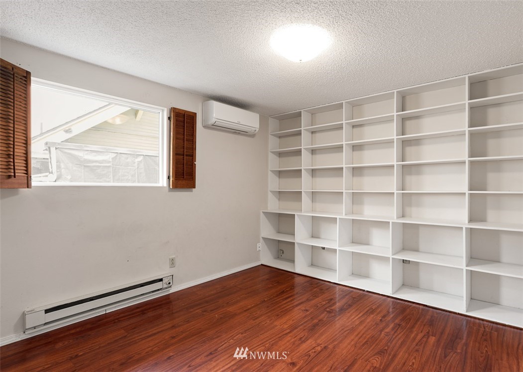 1809 North 41st Street Seattle, WA 98103 - Photo 21 of 32 a view of an empty room with a window and wooden floor