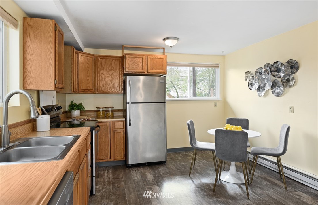 1809 North 41st Street Seattle, WA 98103 - Photo 9 of 32 a kitchen with stainless steel appliances granite countertop a refrigerator a sink a stove and a refrigerator with wooden floor