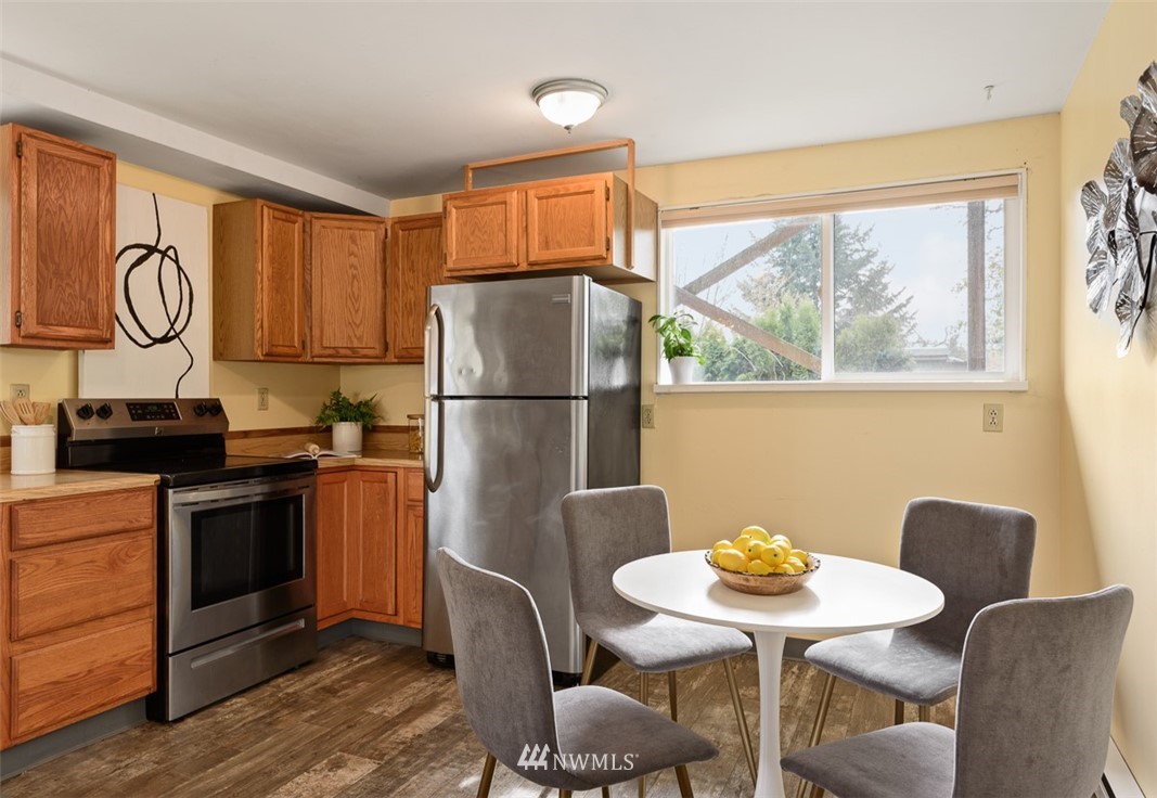 1809 North 41st Street Seattle, WA 98103 - Photo 10 of 32 a kitchen with stainless steel appliances granite countertop a dining table chairs and a refrigerator