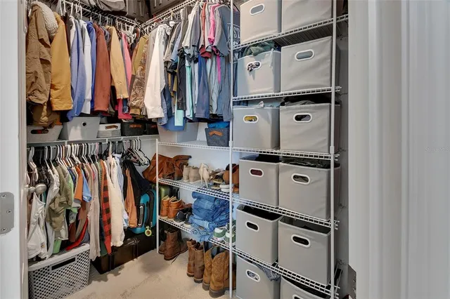 a view of walk in closet with clothes and shoes