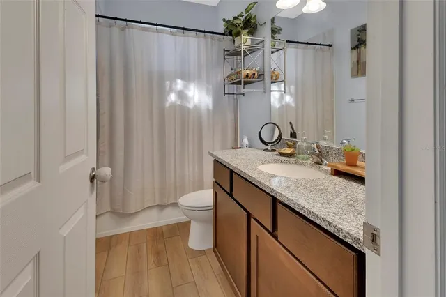 a bathroom with a granite countertop sink toilet and shower