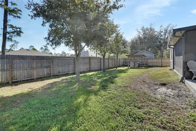 a view of a backyard with a small cabin and wooden fence
