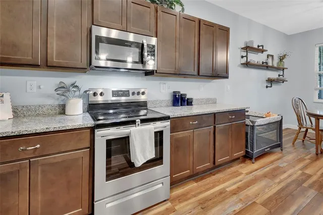 a kitchen with stainless steel appliances granite countertop a stove a microwave and cabinets